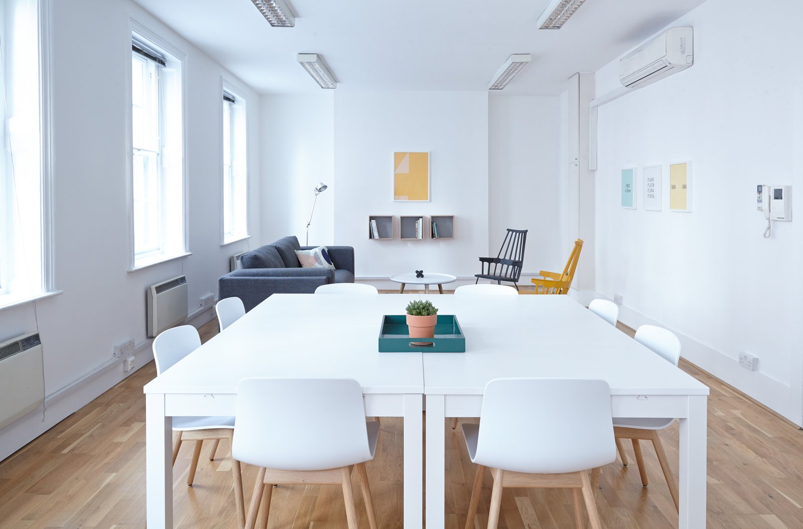 Salle de réunion moderne blanche avec table centrale et coin détente — image d'illustration de l'espace partenaire mis à disposition des CGP par la Financière Outre-Mer