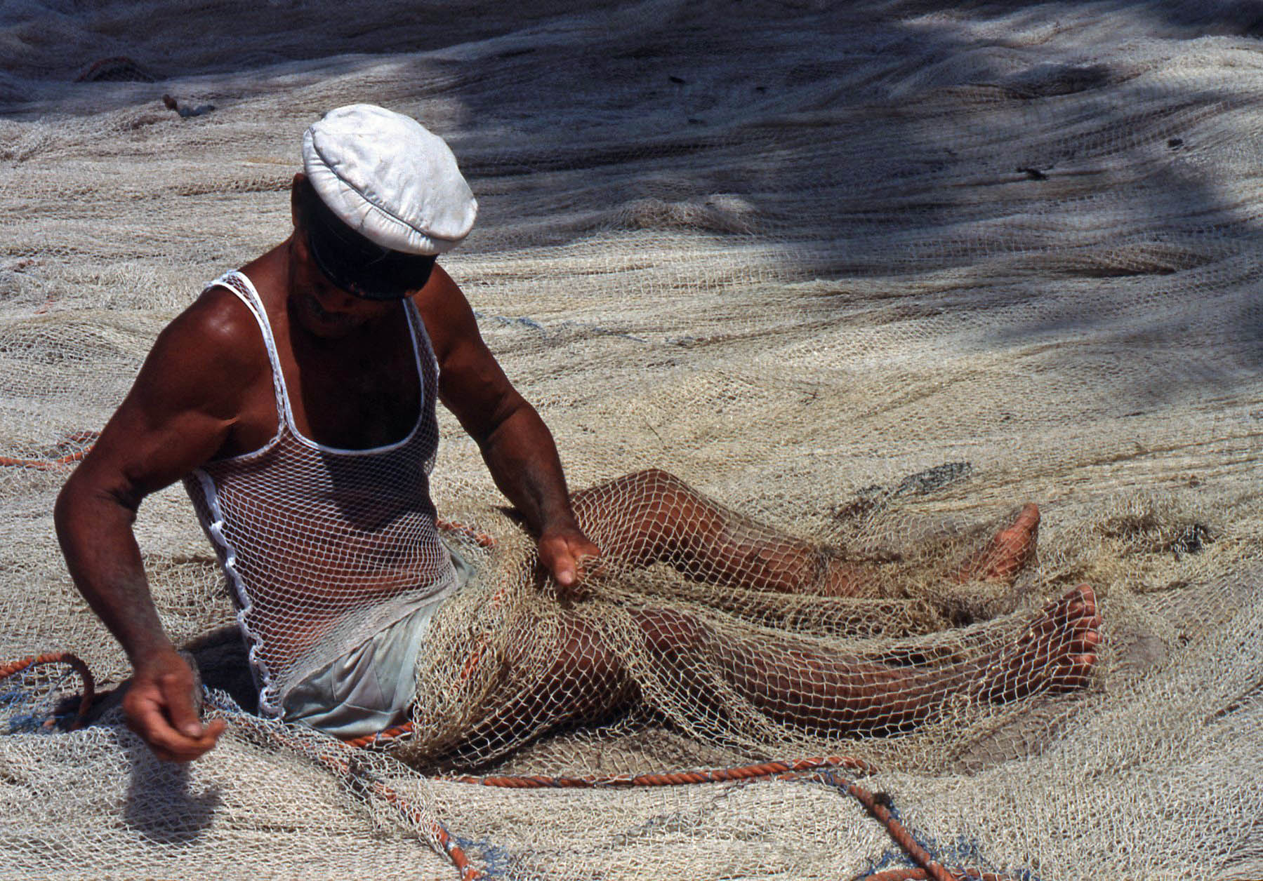 Pêcheur réparant un filet en Martinique — matériel artisanal éligible Girardin industriel